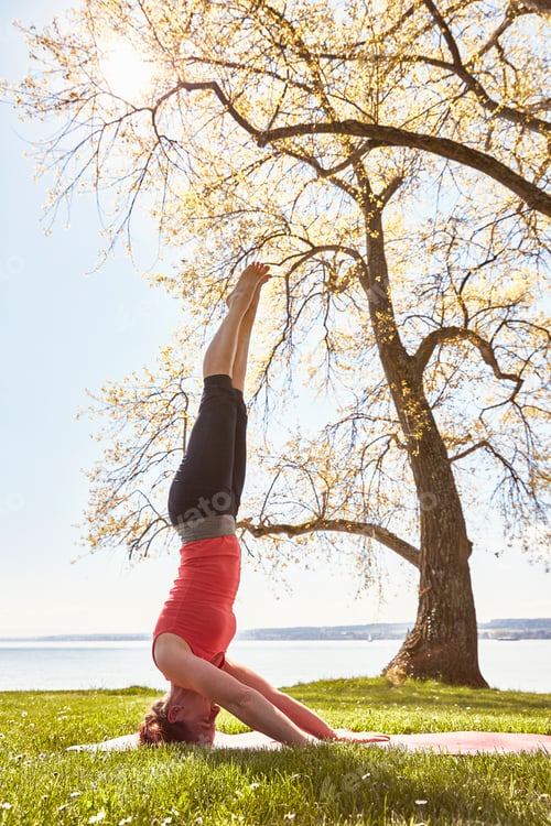 Preview: Side view of woman doing headstand