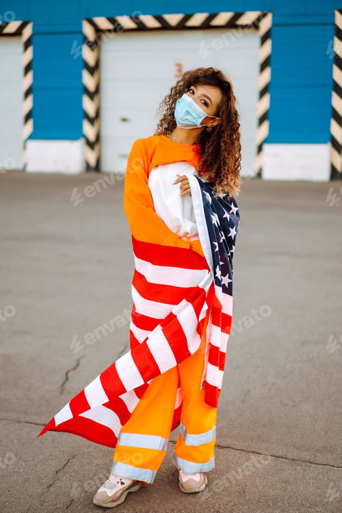 Preview: African woman with face mask posing with american flag.concept of preventing spread of epidemic.