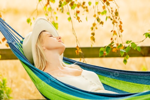Preview: Tired mother tries to sleep in hammock in garden