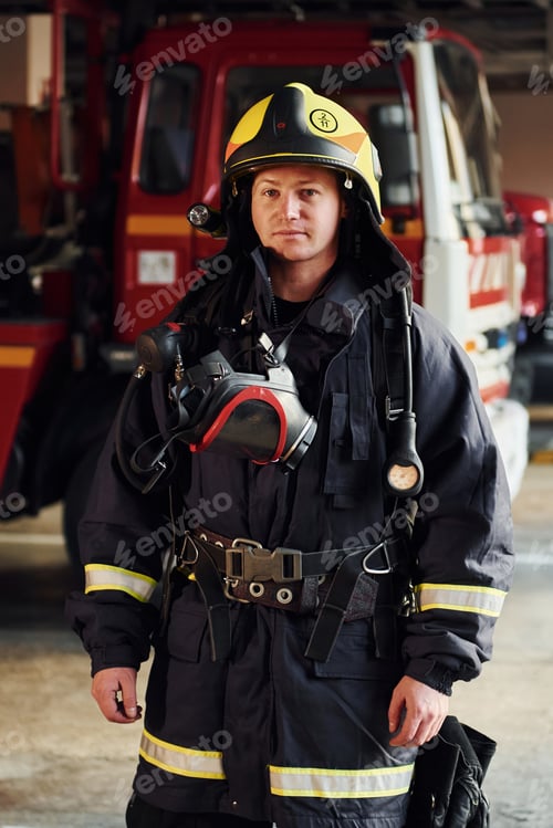 Preview: Female firefighter in protective uniform standing near truck