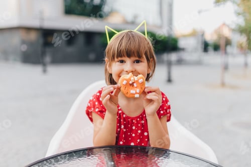 Preview: Girl with donut at cafe table