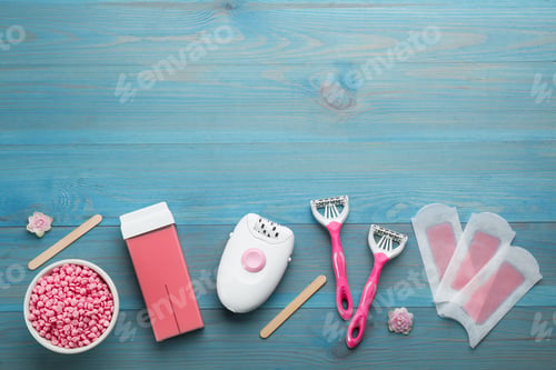 Preview: Set of epilation products on light blue wooden table, flat lay. Space for text