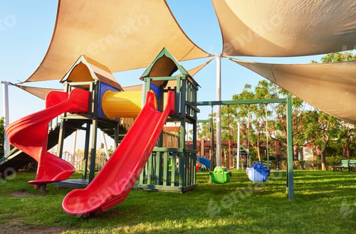 Preview: Colorful playground in the yard in the park at sunset