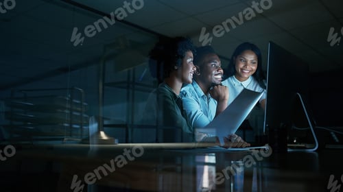 Preview: Shot of a group of young businesspeople using a computer together during a late night at work