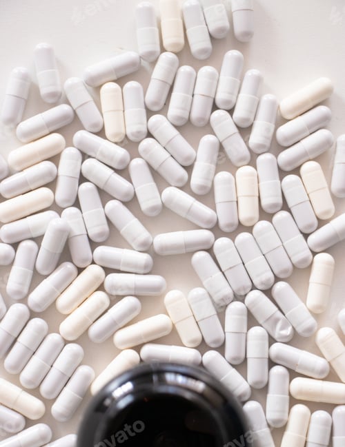 Preview: Medicine capsules and bottle on a white table