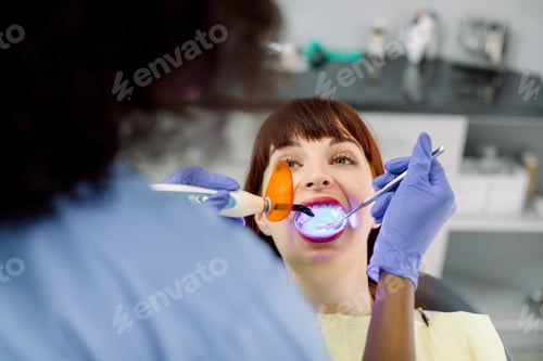 Preview: Close up of face of young woman patient having dental treatment.