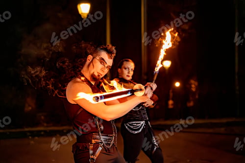 Preview: Fire dancers performing with burning staffs at night