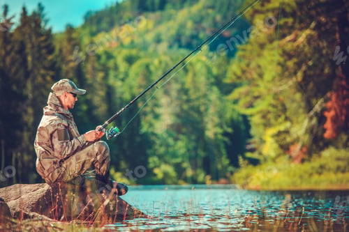 Preview: Fisherman Sits on Rock by the River During Sunny Day