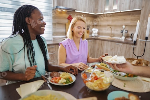 Preview: Friends share a delightful meal in a cozy kitchen setting