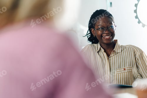 Preview: Young manager smiling during a business meeting in the office