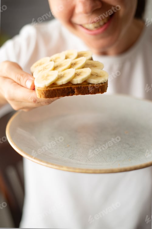 Preview: Woman Holding Tasty Banana and Peanut Butter Toast