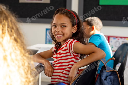 Preview: In school, three children wearing casual clothes are sitting at desks in a classroom