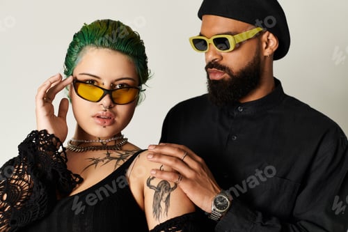 Preview: Stylish multicultural couple poses in trendy sunglasses in modern studio setting
