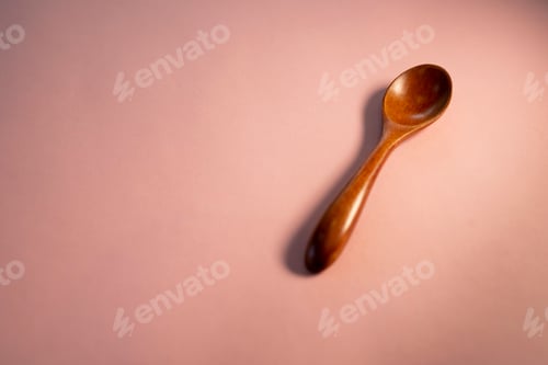 Preview: Wooden spoon on isolated pink background