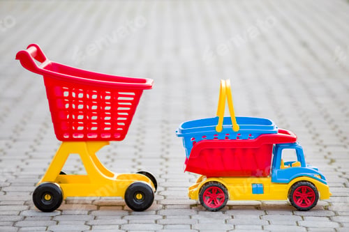 Preview: Bright plastic colorful toys for children outdoors on sunny summer day. Car truck, basket and
