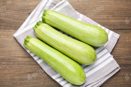 Preview: Fresh ripe zucchinis on wooden table, top view