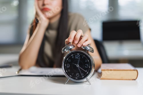 Preview: Tired woman turning off alarm clock in morning