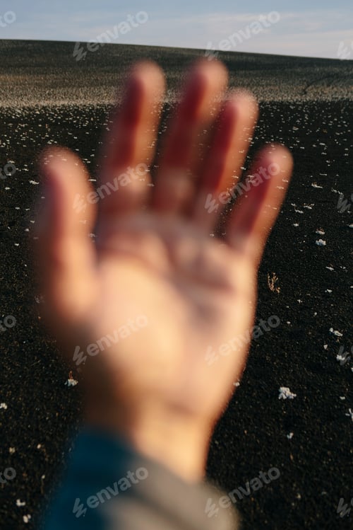 Preview: Solidified lava fields in Idaho, with a person's hand in the foreground.