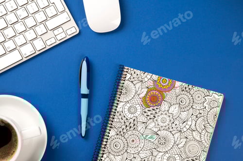Preview: Blue office desk with notebook, pen, keyboard, mouse and a coffee
