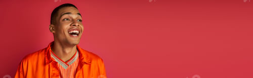 Preview: astonished african american man, laughing, looking away, orange shirt, red background, banner