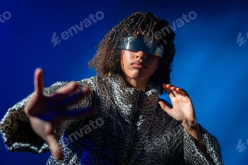Preview: Trendy woman wearing futuristic visor and reaching out hand