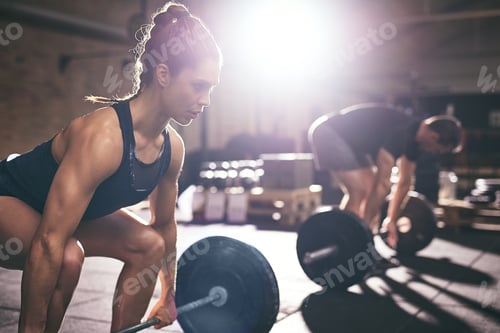 Preview: Muscular man and woman lifting heavy barbells
