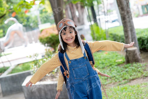 Preview: A cute little girl dressed in a cap and glasses of a pilot. The child dreams of becoming a pilot.