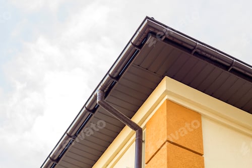 Preview: Close-up detail of cottage house corner with brown metal planks siding and roof