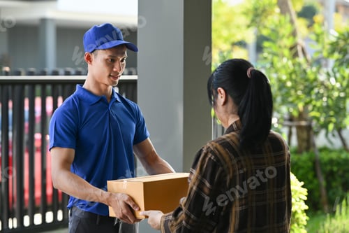 Preview: Delivery man giving postal package to customer at doorway.