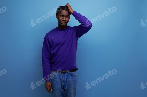 Preview: portrait of a doubtful dark-skinned european young adult in a blue hoodie and jeans isolated on a