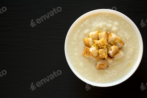 Preview: Homemade Cauliflower Soup with Croutons and Oil, top view. Flat lay, overhead, from above.