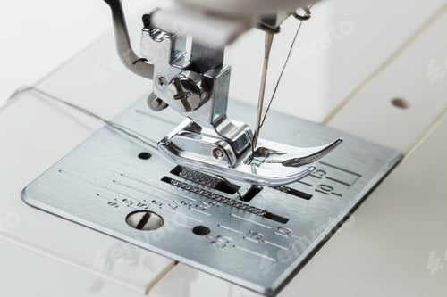 Preview: Sewing machine needle working on fabric during daytime stitching