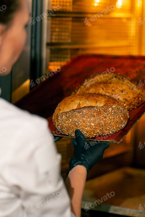 Preview: Close-up shot of hot freshly baked bread standing on a baking tray and being finished in the oven on