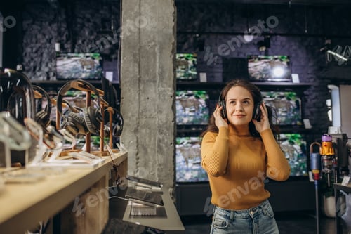 Preview: Woman trying on headphones in acoustics store.