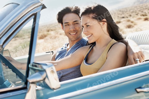 Preview: A young couple, man and woman in a pale blue convertible on the open road