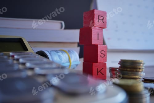 Preview: Wooden cubes with text RISK surrounded by calculator and money.