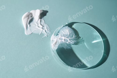 Preview: A smear of cream against a background of glass prisms on a blue background.
