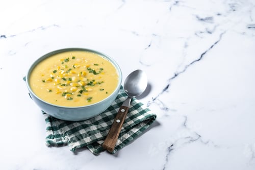 Preview: Corn soup in green bowl on white marble