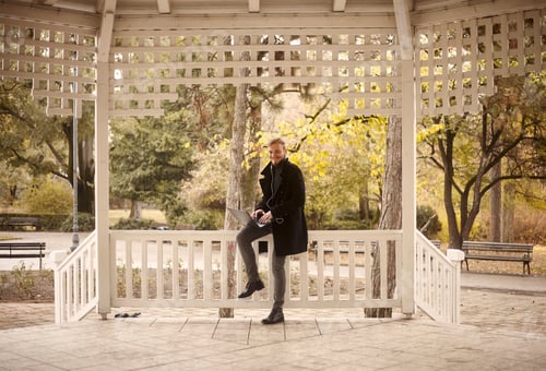 Preview: One Smiling Young Man, 20-29 Years Old, Sitting On Fence Outdoors In Park, While Using His Laptop