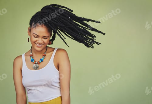 Preview: Funky meets femininity. Shot of an attractive young woman posing against a green background.