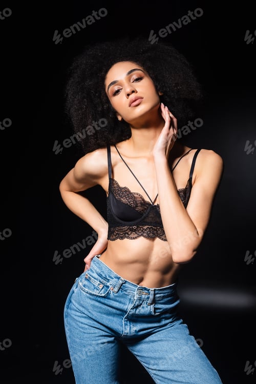 Preview: African american woman in lace bra and jeans on black background