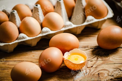 Preview: Chicken eggs on wooden table.