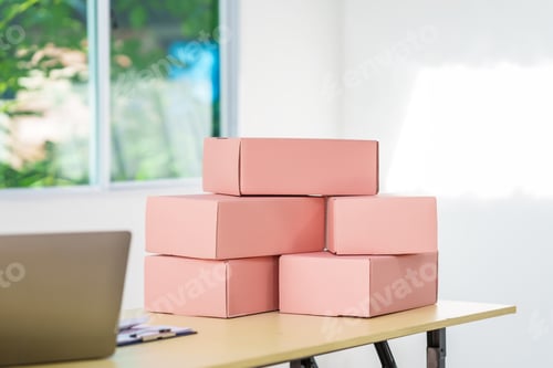 Preview: A pink cardboard box for shipping, mail, and multipurpose use sits on the work desk. Ideal for gifts