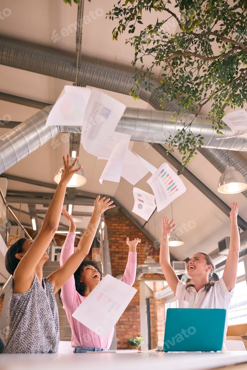 Preview: Businesswomen Meeting In Modern Office Sitting Around Table Celebrating Throwing Documents