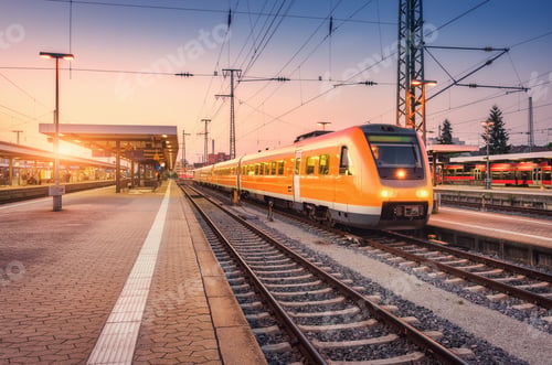 Preview: Orange high speed train on the railway station at sunset