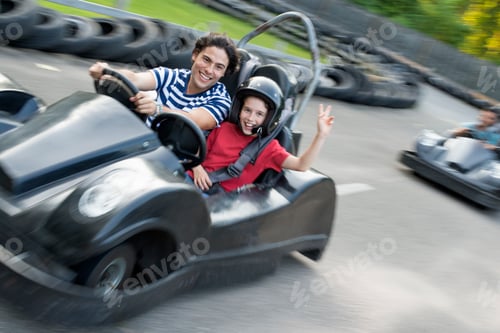 Preview: Boys and men go-karting on a track.