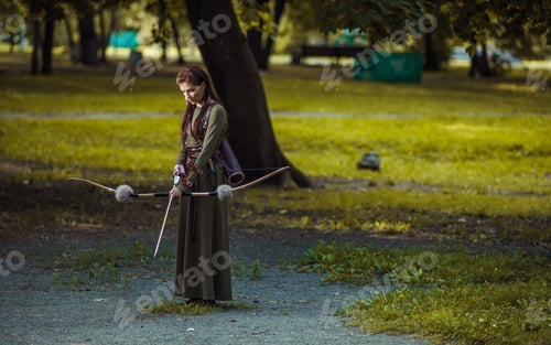 Preview: Warrior medieval woman with bow hunting in green forest