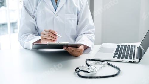 Preview: Doctor is sitting and reading medical report in his hospital office