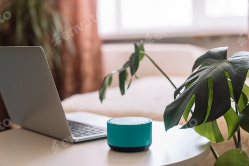 Preview: Blue wireless smart speaker on white table with laptop in room