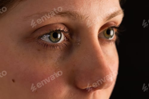 Vista previa: Face of unhappy female in tears from close up in darkness